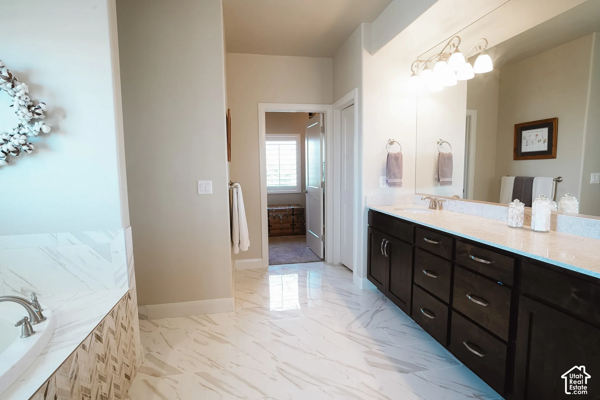 Spacious bathroom featuring a dual vanity with dark wood cabinetry and light-toned countertops