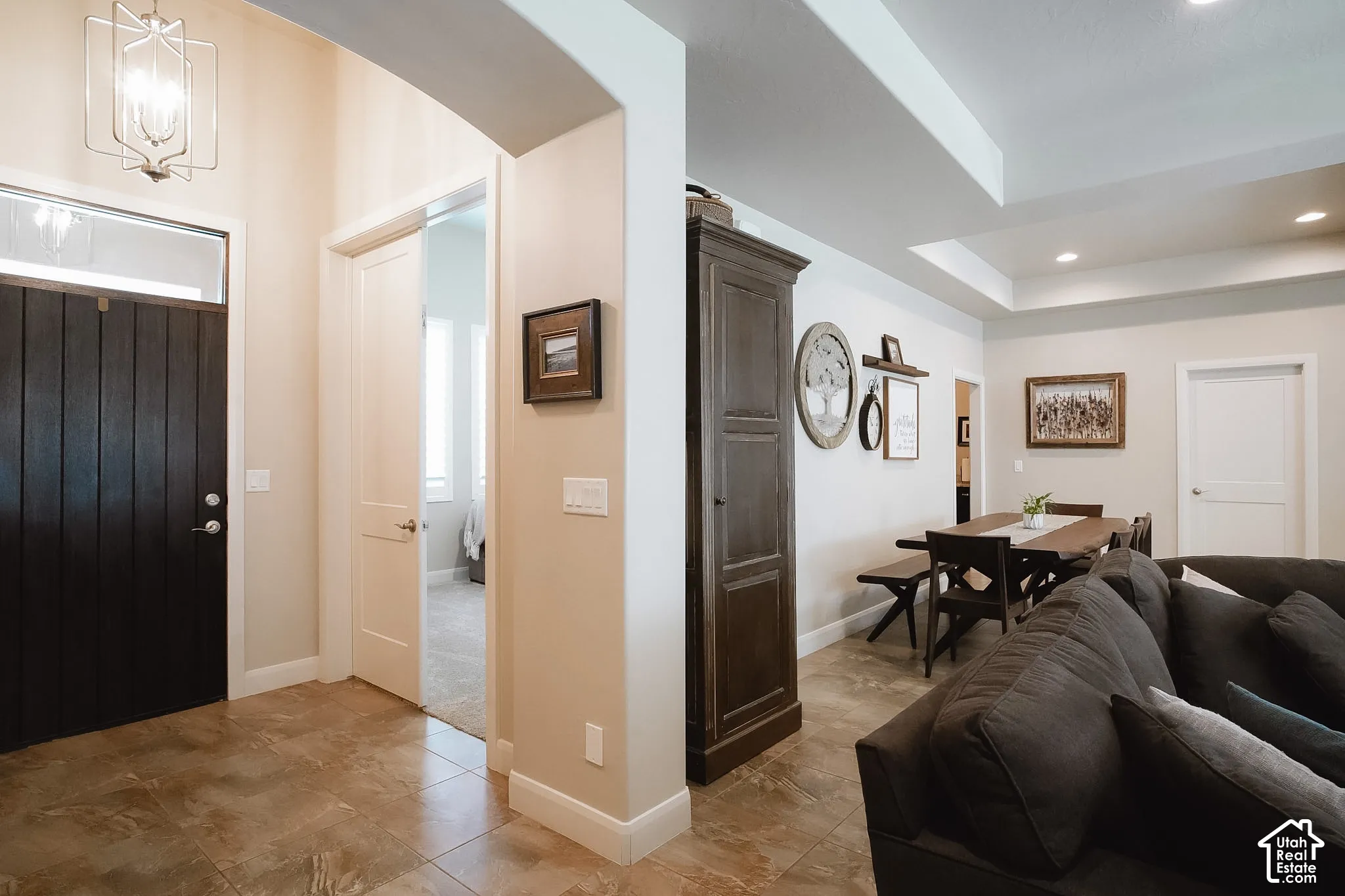 Entryway featuring a dark wood-paneled door with transom window, tile flooring, and a contemporary pendant light fixture