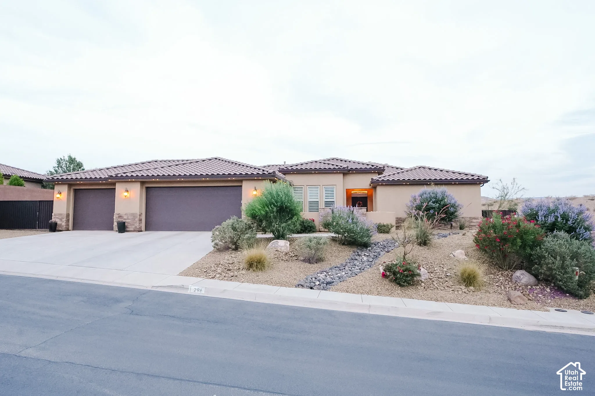 Contemporary stucco exterior with a tile roof and integrated two-car garage