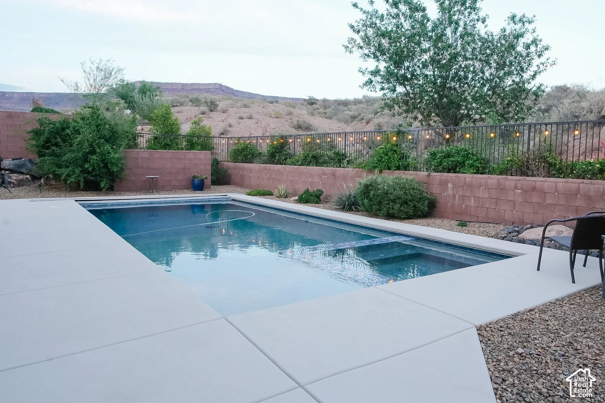 Rectangular swimming pool with integrated spa and expansive concrete decking