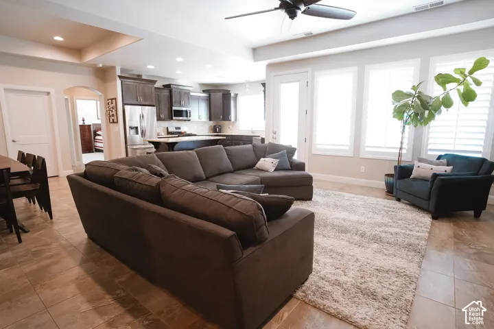 Open-concept living area featuring tile flooring, a ceiling fan, and recessed lighting
