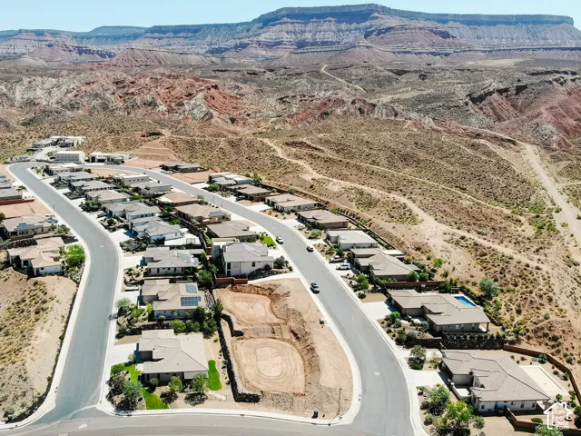 Residential development featuring single-story homes, paved streets, and a desert landscape backdrop