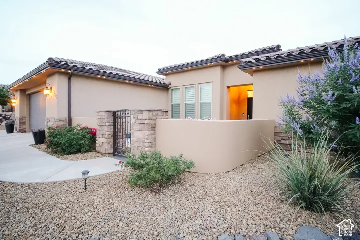 Stucco exterior featuring stone accents and a tiled roofline