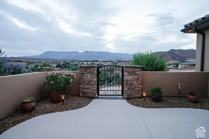Outdoor patio area featuring a decorative wrought iron gate and stone-clad pillars