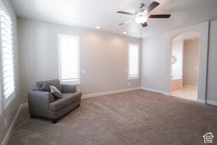 Spacious room featuring neutral carpeting, recessed lighting, and a ceiling fan