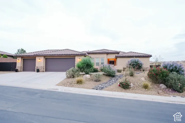 Contemporary stucco exterior with a tile roof and integrated two-car garage
