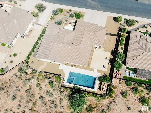 Expansive outdoor area featuring a rectangular pool with an integrated spa, extensive hardscaping, and desert landscaping