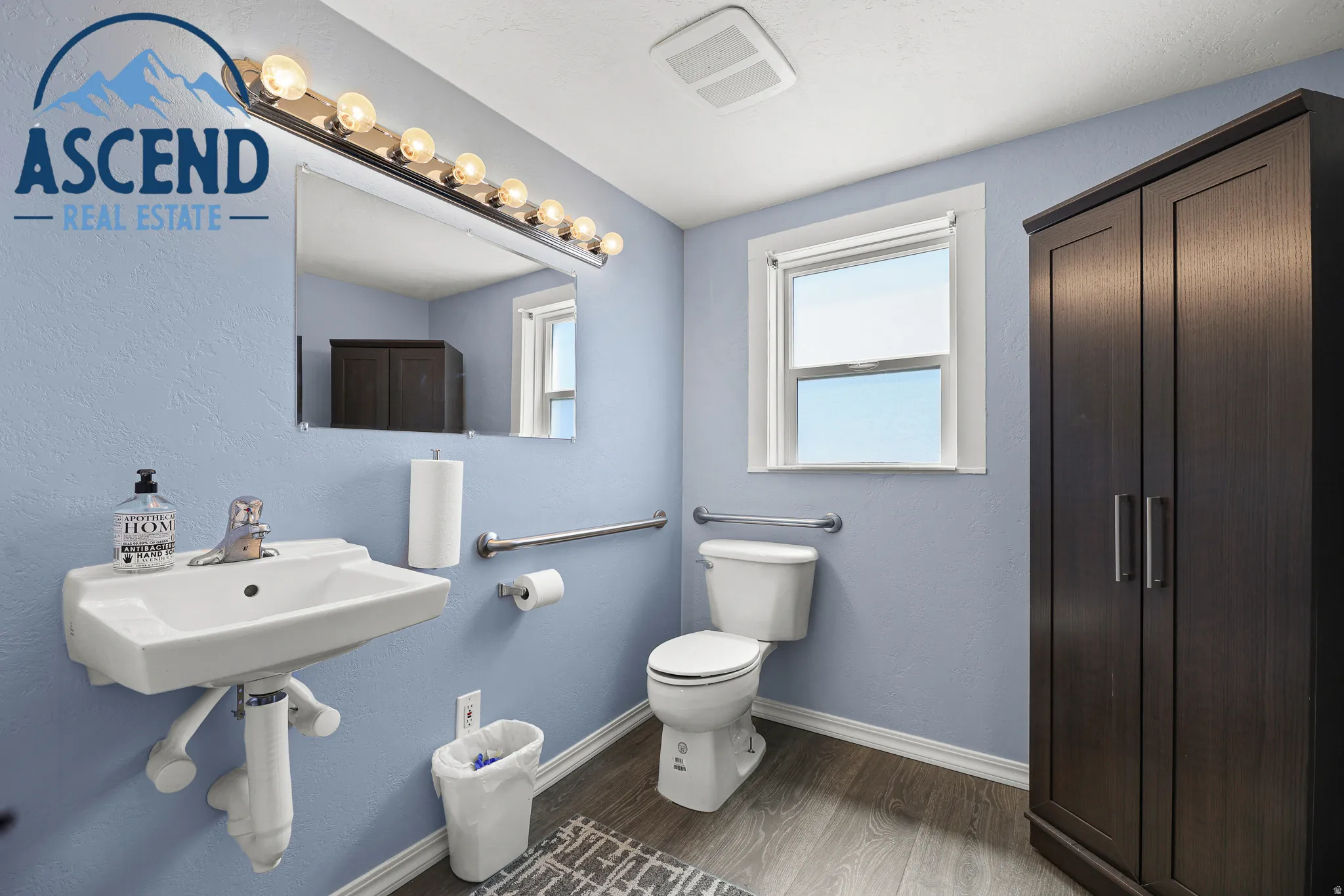Bathroom featuring a wall-mounted sink and toilet. Handicap accessible