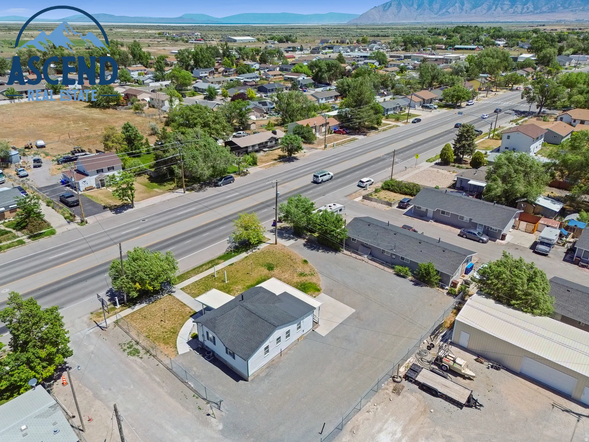 Aerial perspective showcasing a single-story structure with a large gravel parking lot.