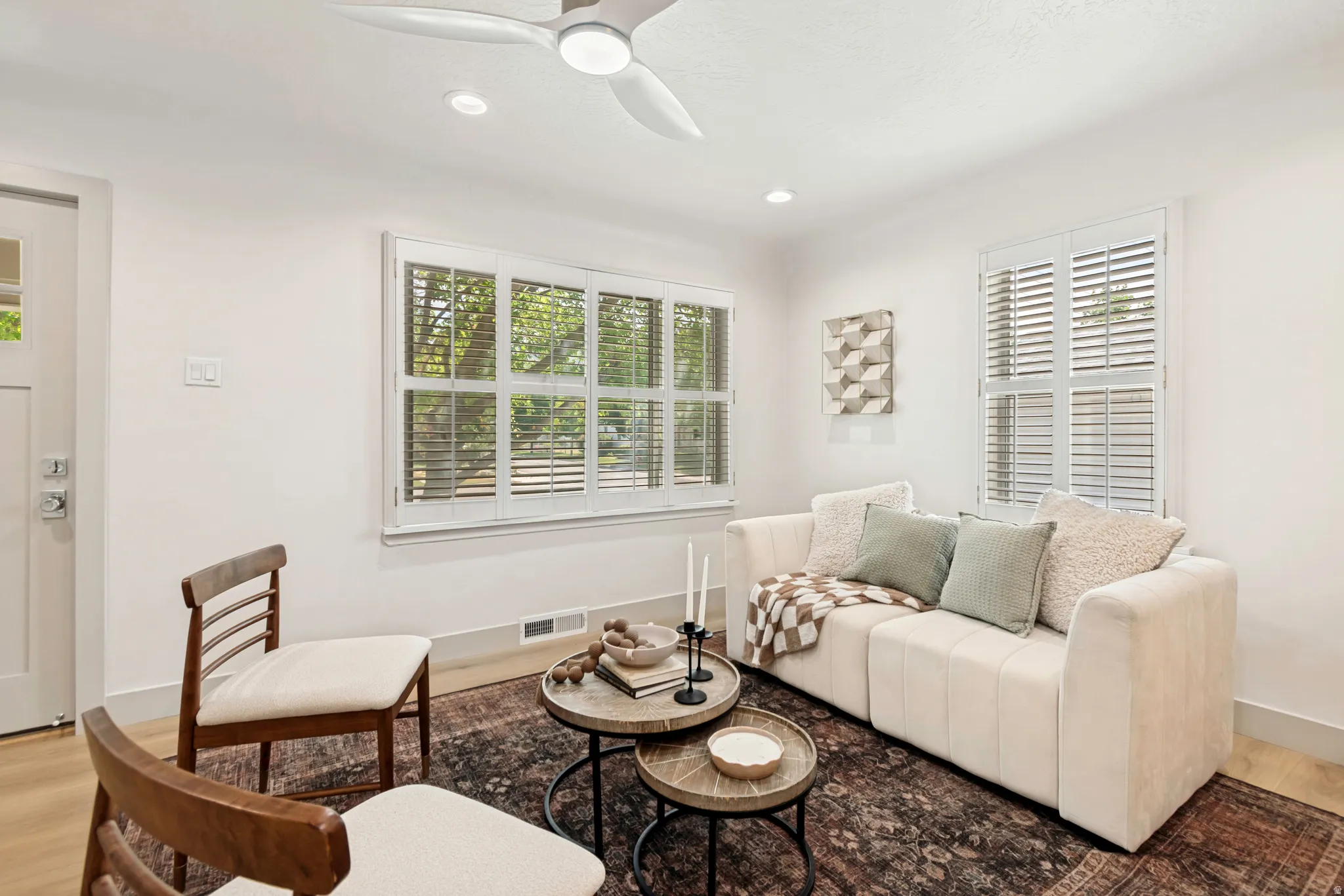 Living area featuring wood-finish flooring, white walls, and a contemporary ceiling fan