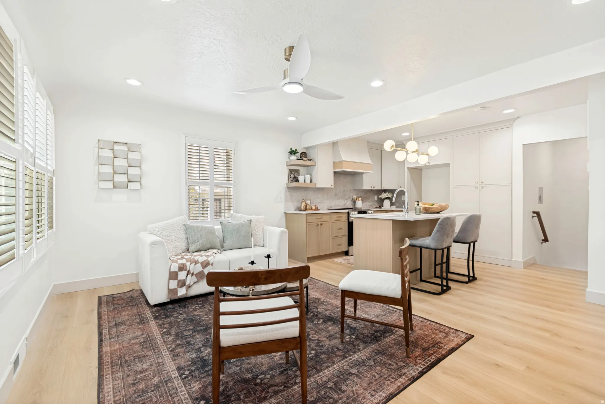 Open-concept living space featuring wood-finish flooring, recessed lighting, and a modern ceiling fan