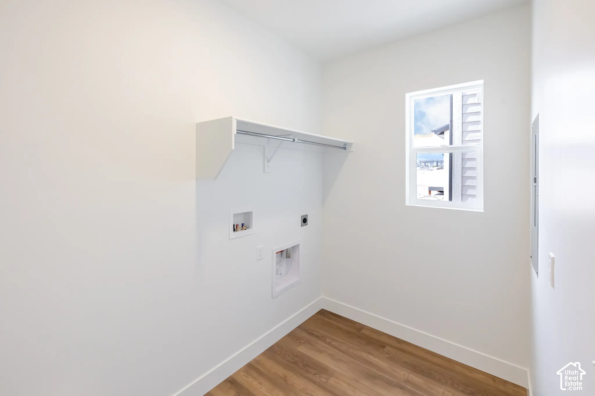 Wood-finish flooring, white walls, and a window with white louvered blinds