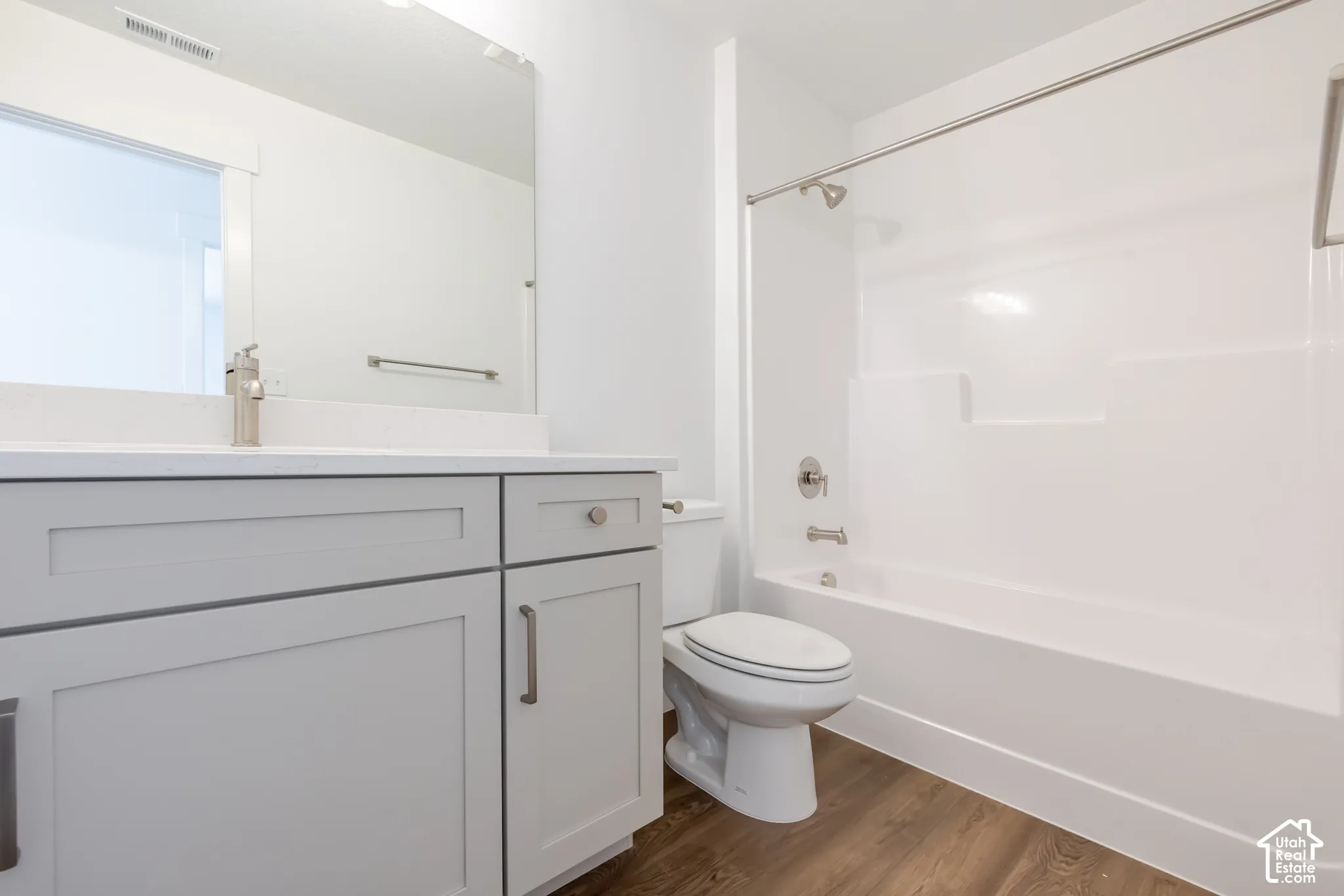 White vanity with a light-toned countertop, brushed nickel faucet, and undermount sink