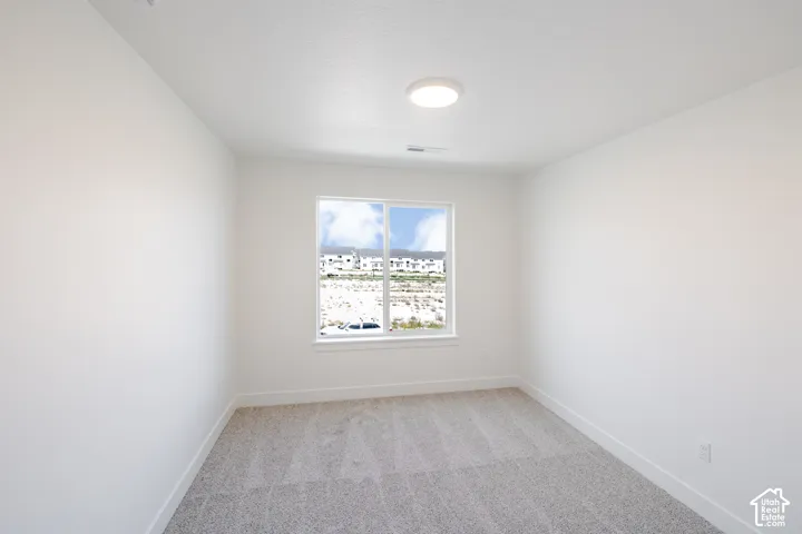 Recessed window with white trim, gray patterned carpet, and a flush-mount ceiling light