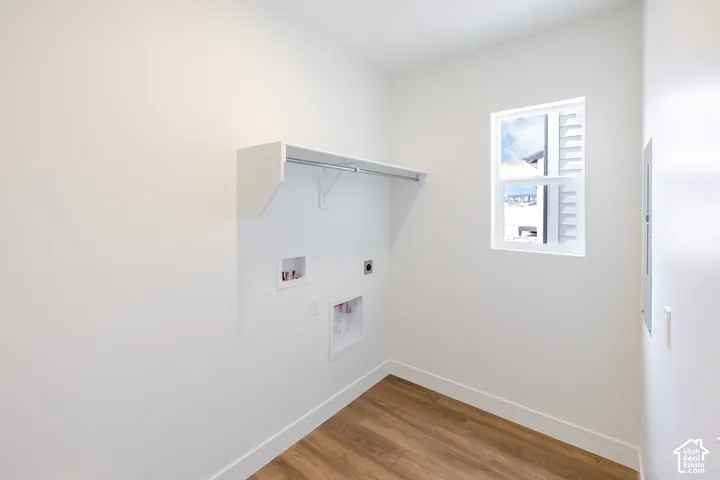 Wood-finish flooring, white walls, and a window with white louvered blinds