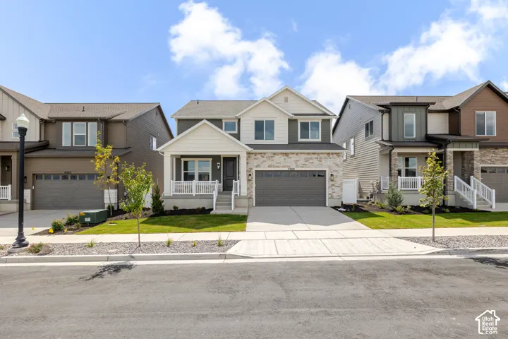 Two-story exterior with stone and siding accents, covered front porch, and a two-car garage