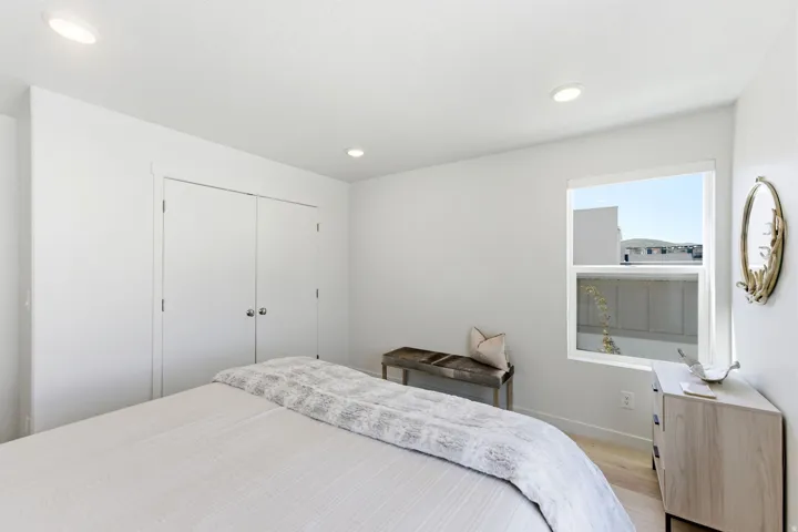 Bedroom featuring wood-finish flooring, a window with exterior views, and recessed lighting