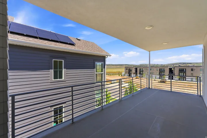 Expansive outdoor balcony featuring a solid ceiling with recessed lighting and a contemporary metal railing