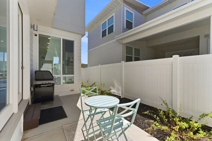 Private patio featuring concrete flooring and a white privacy fence