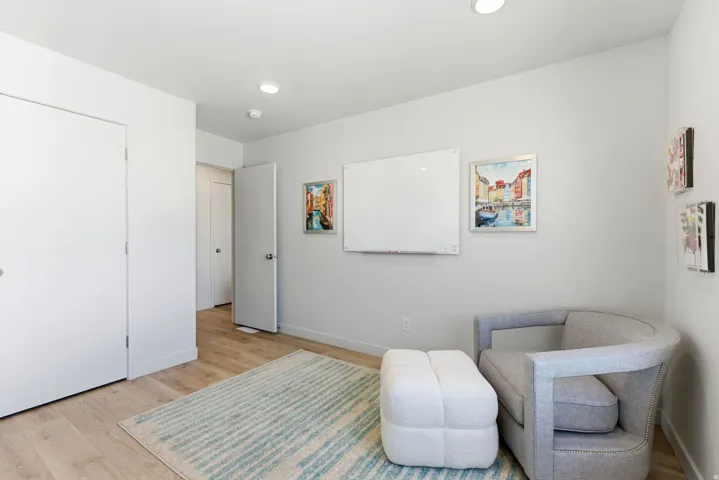 Recessed ceiling lighting, light wood-finish flooring, white baseboards, solid core doors, and painted walls