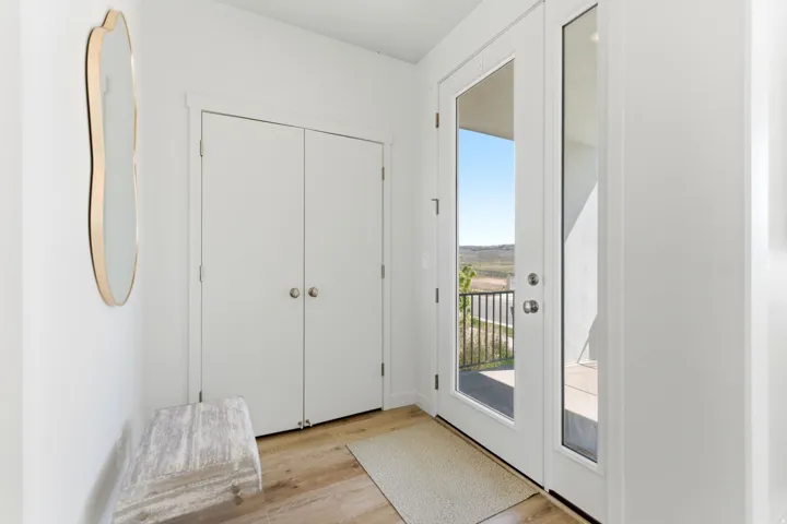 Entryway with double French doors, wood-finish flooring, and a double-door closet
