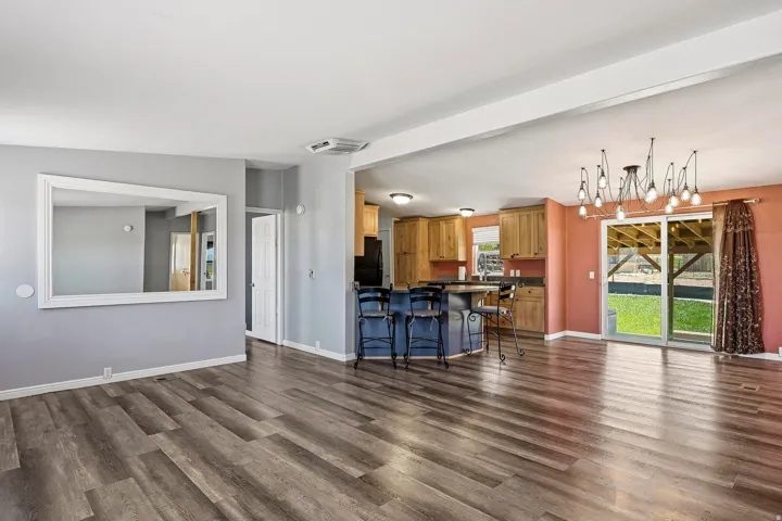 Expansive open-concept living space with wood-finish flooring
