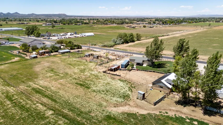 Expansive acreage featuring multiple structures, open fields, and mature trees