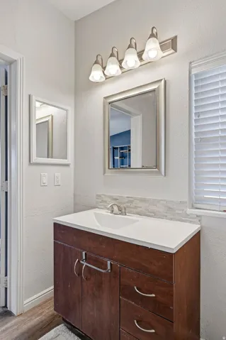 Bathroom vanity featuring a white countertop, undermount sink, and brushed nickel faucet