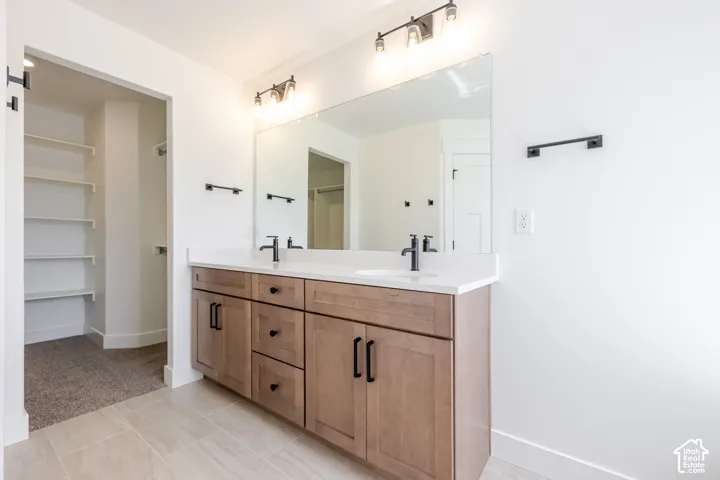 Dual vanity with wood-finish cabinetry, white countertop, and matte black fixtures
