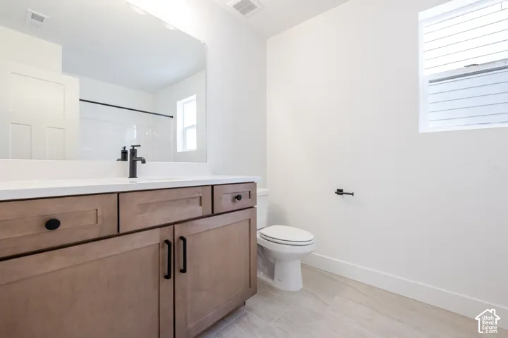 Contemporary vanity with wood-finish cabinetry and matte black hardware