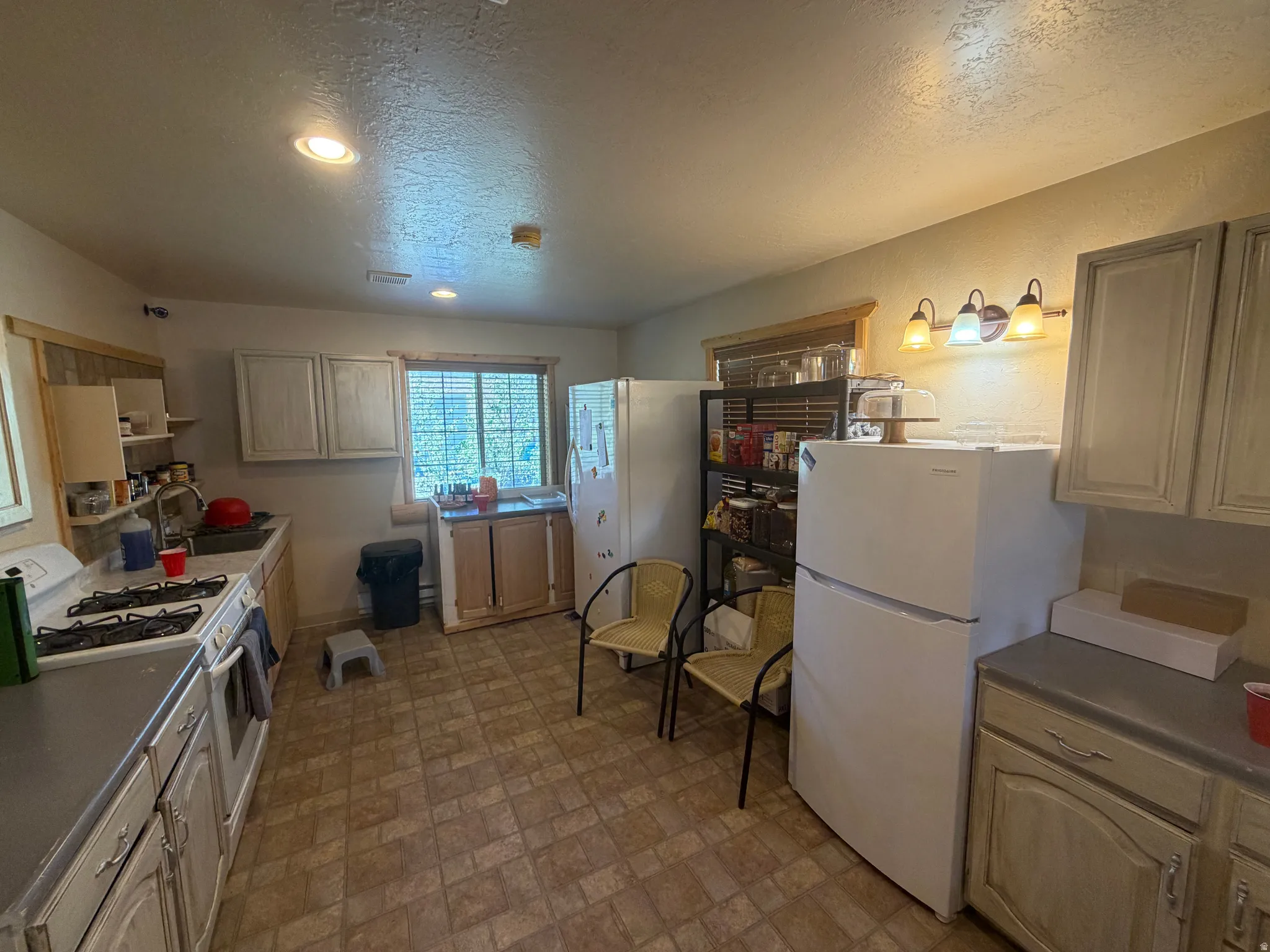 Kitchen featuring patterned tile flooring, wood-finish cabinetry, and recessed lighting
