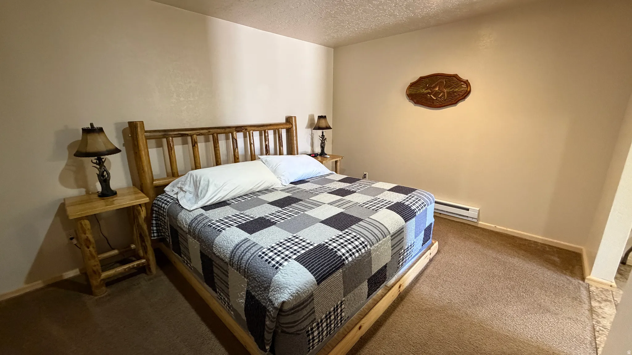 Bedroom featuring light beige walls and textured carpet flooring