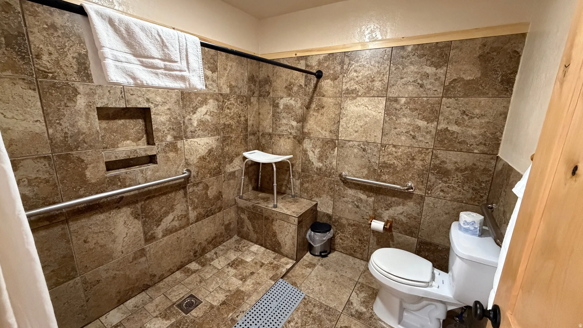 Tiled shower with integrated bench seating and recessed shelf