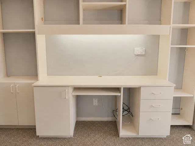 Built-in desk with integrated shelving, and under-cabinet lighting.