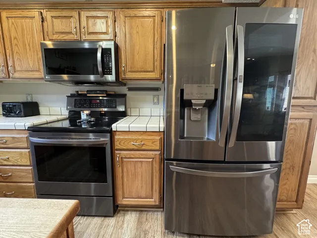 Premium black stainless steel LG  appliance package includes French door refrigerator with integrated ice and water dispenser, oven, microwave, and dishwasher.