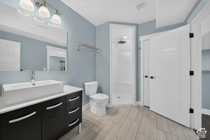 Modern vanity with a rectangular vessel sink, a full-width mirror, and a contemporary light fixture