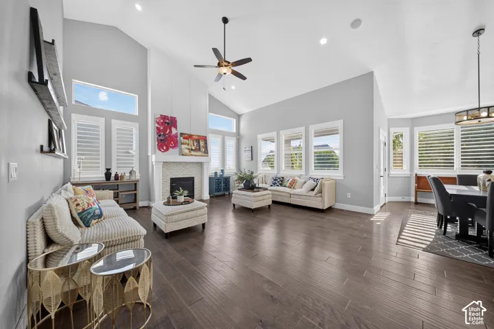 Expansive great room with soaring vaulted ceilings, ceiling fan, and abundant natural light from multiple transom windows.