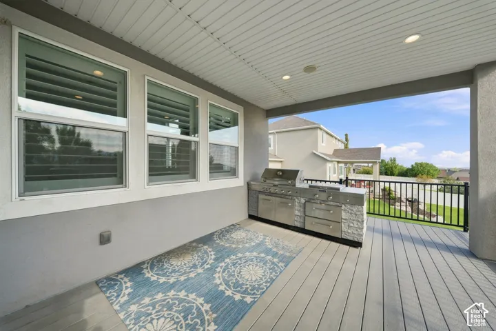 Covered outdoor deck with a built-in grill station, recessed lighting, and a durable composite deck surface