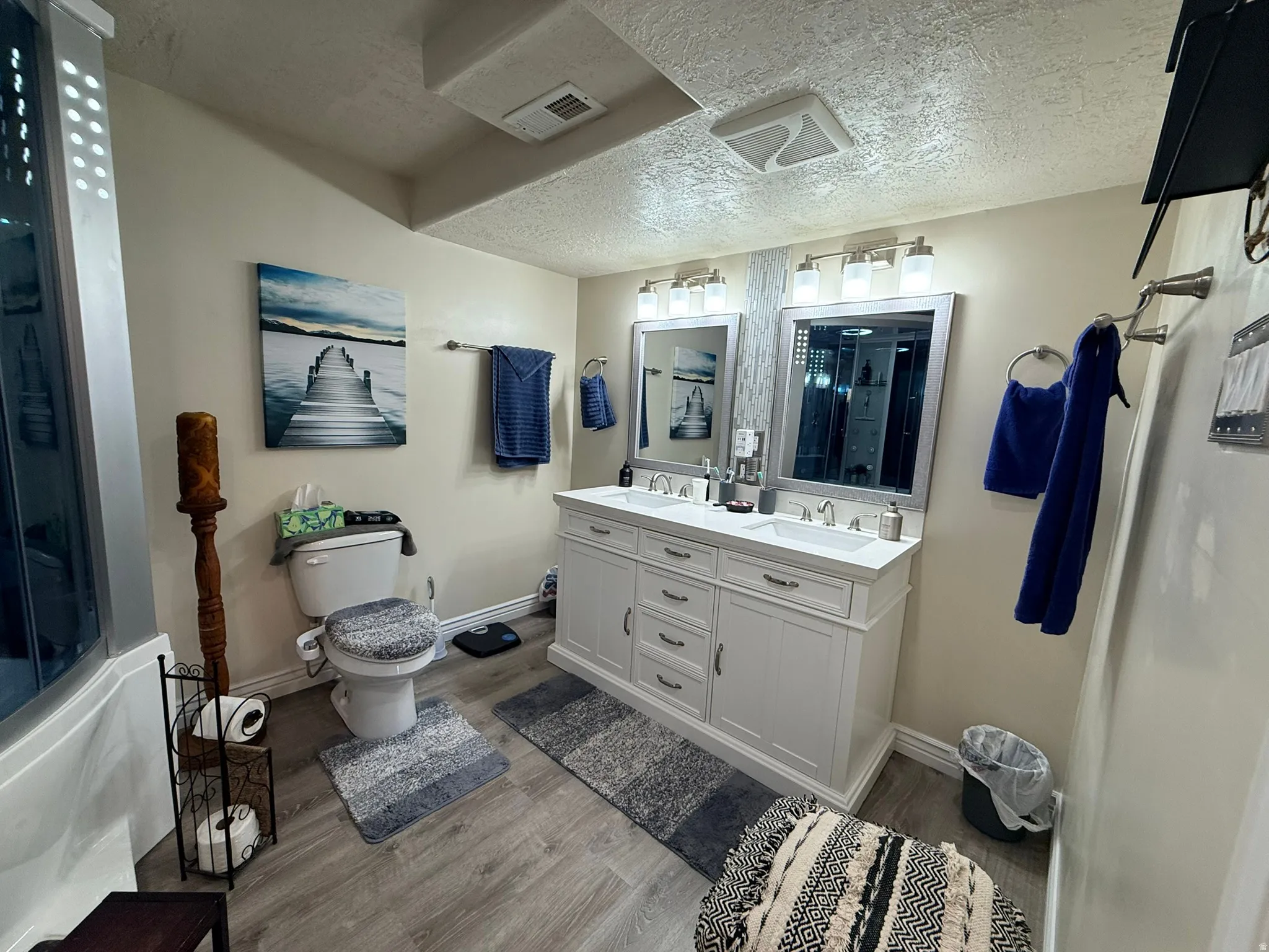 Spacious bathroom featuring a double vanity with white cabinetry and undermount sinks, flanked by rectangular framed mirrors