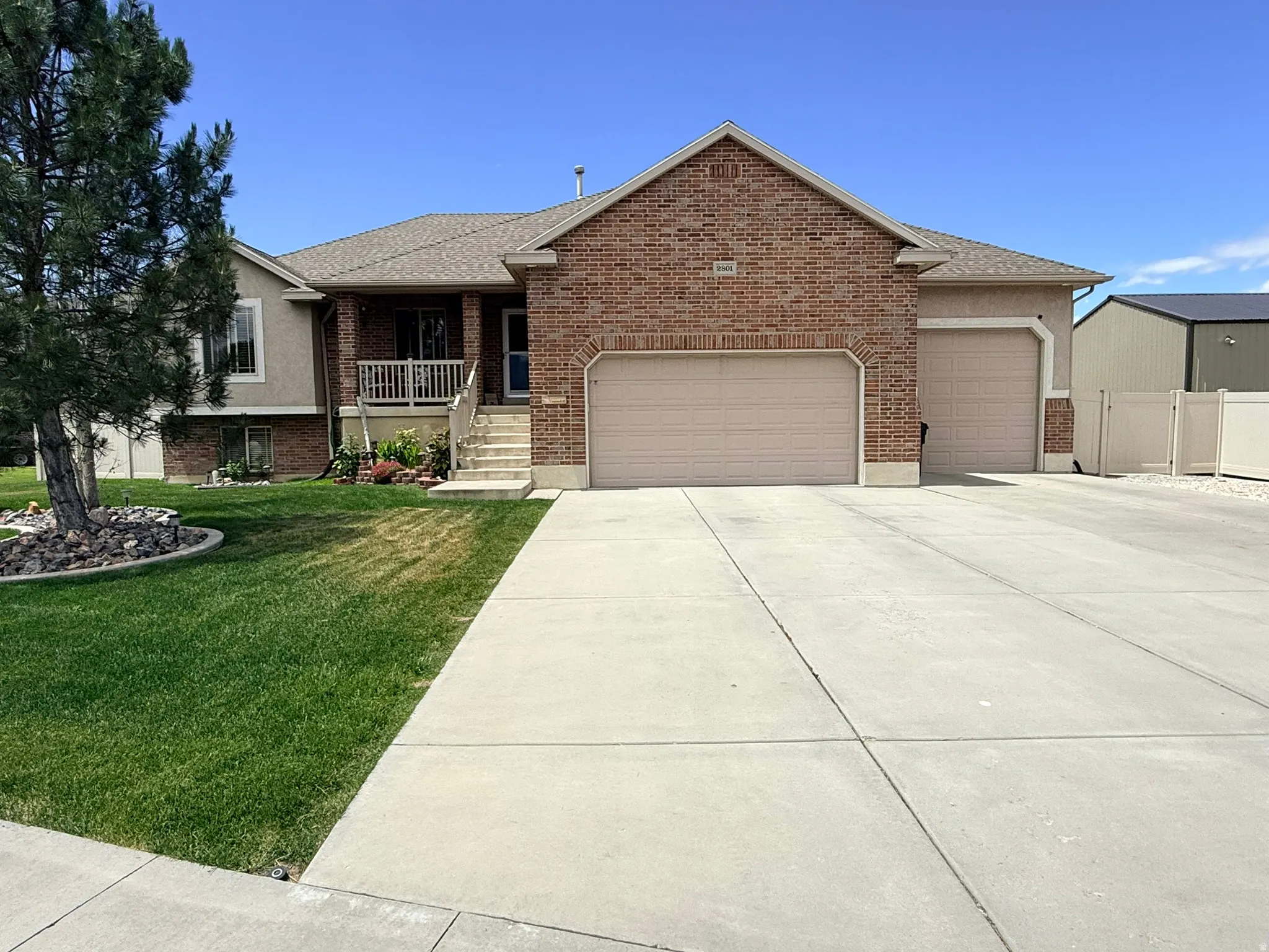 Brick and stucco exterior with a two-car garage and additional single-car garage