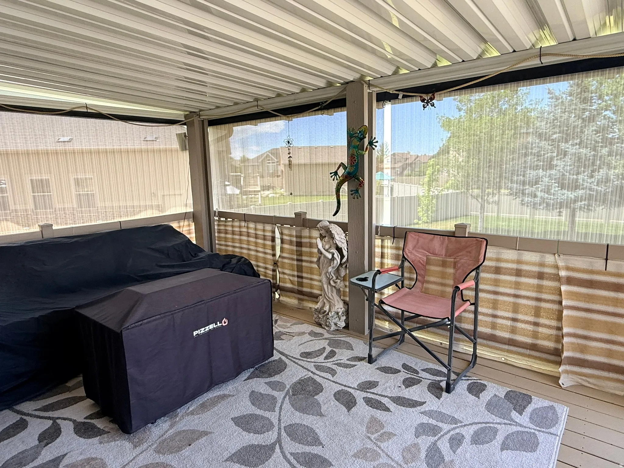 Covered patio with a corrugated metal roof, screened enclosures, and a light-colored wood-finish deck