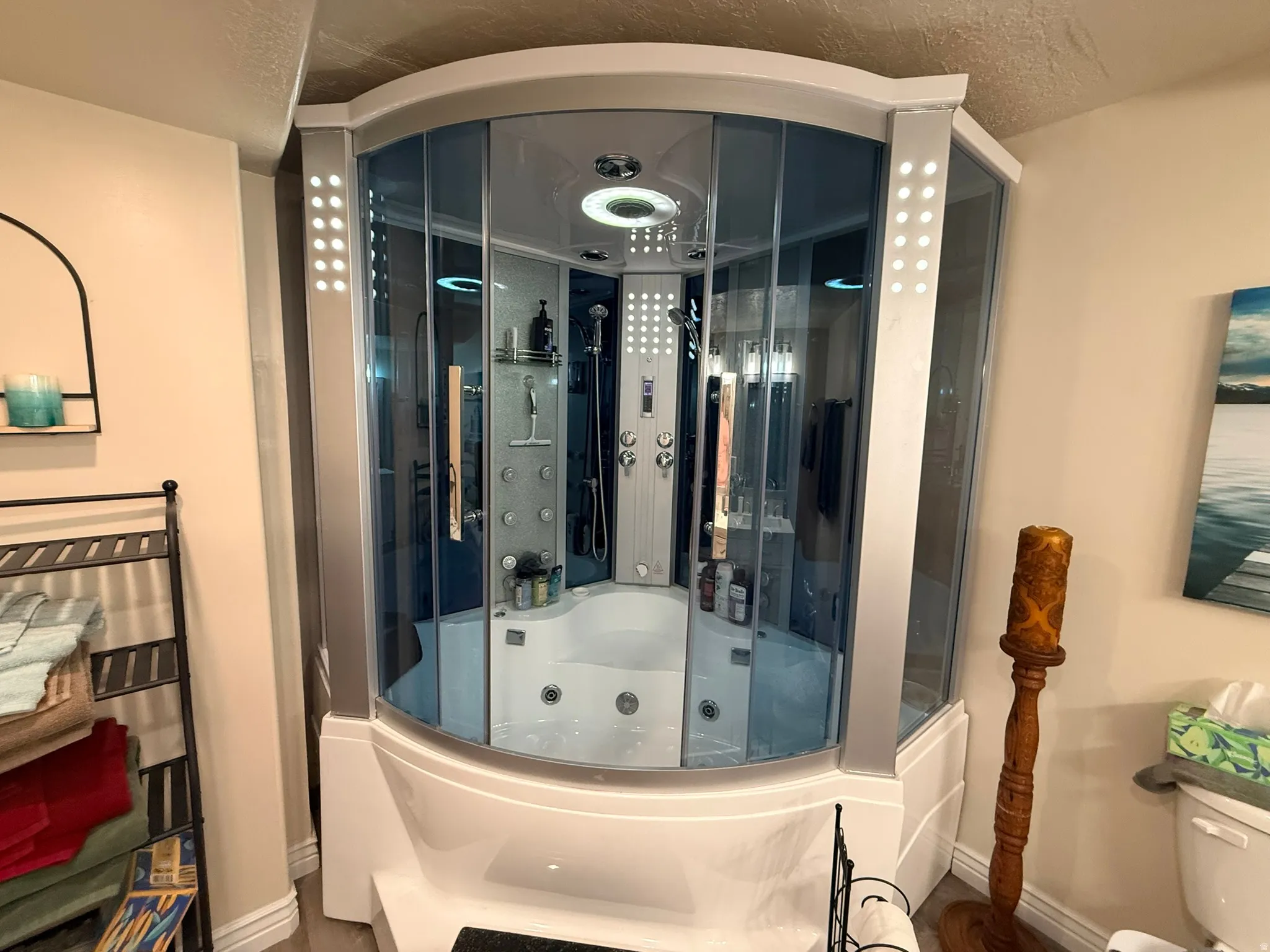 Corner shower enclosure featuring clear glass panels, an integrated soaking tub, and a multi-jet shower system