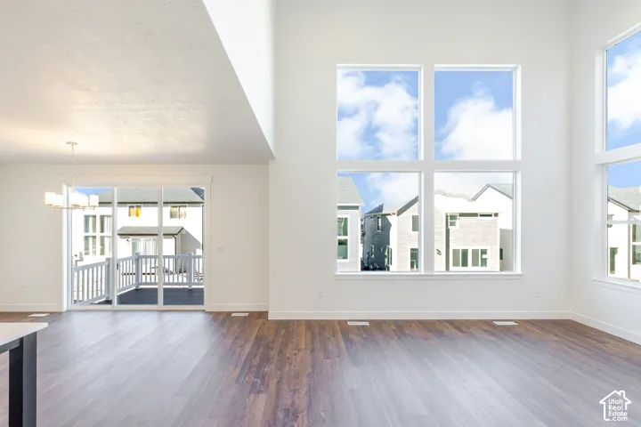 Bright, open great room featuring soaring vaulted ceilings with skylights, abundant natural light from multiple large windows, and warm wood-finish flooring throughout