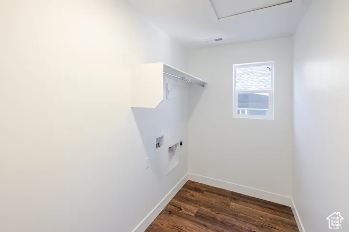 Wood-finish flooring, white walls, and a window with blinds