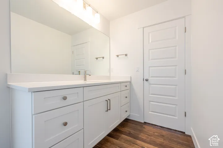 White shaker-style vanity with ample storage, integrated basin, and brushed nickel hardware