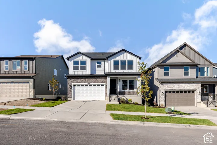 Two-story home with a white vertical siding exterior and dark trim accents