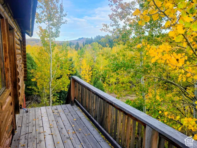 Wood-sided exterior featuring a natural wood deck with a wooden railing