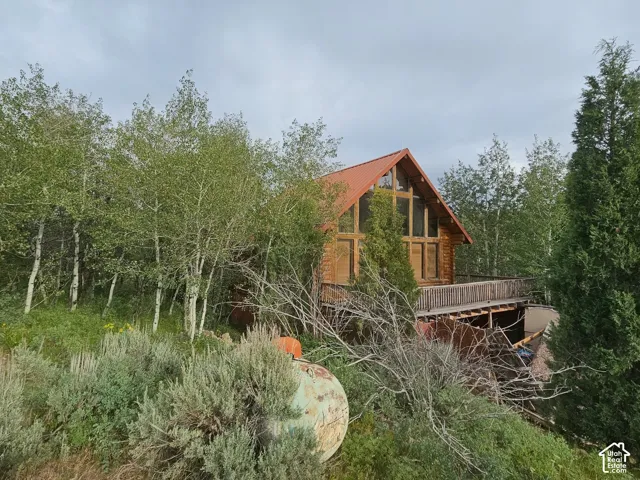 Wood-sided home featuring a prominent A-frame design with a red metal roof