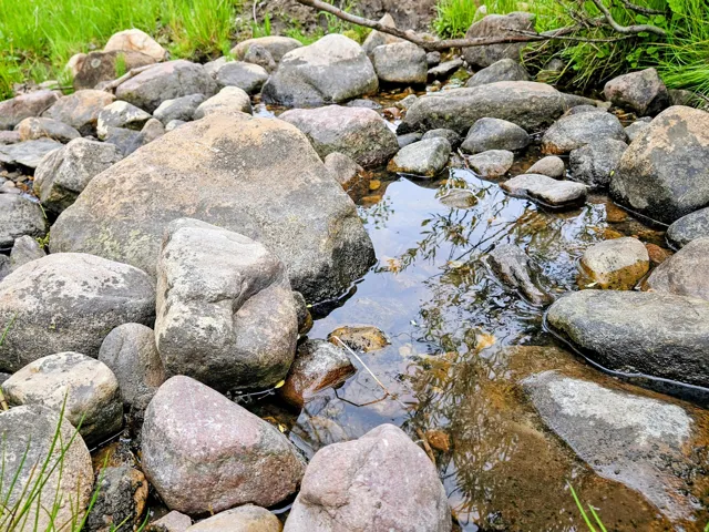Natural rock-lined creek bed featuring clear water