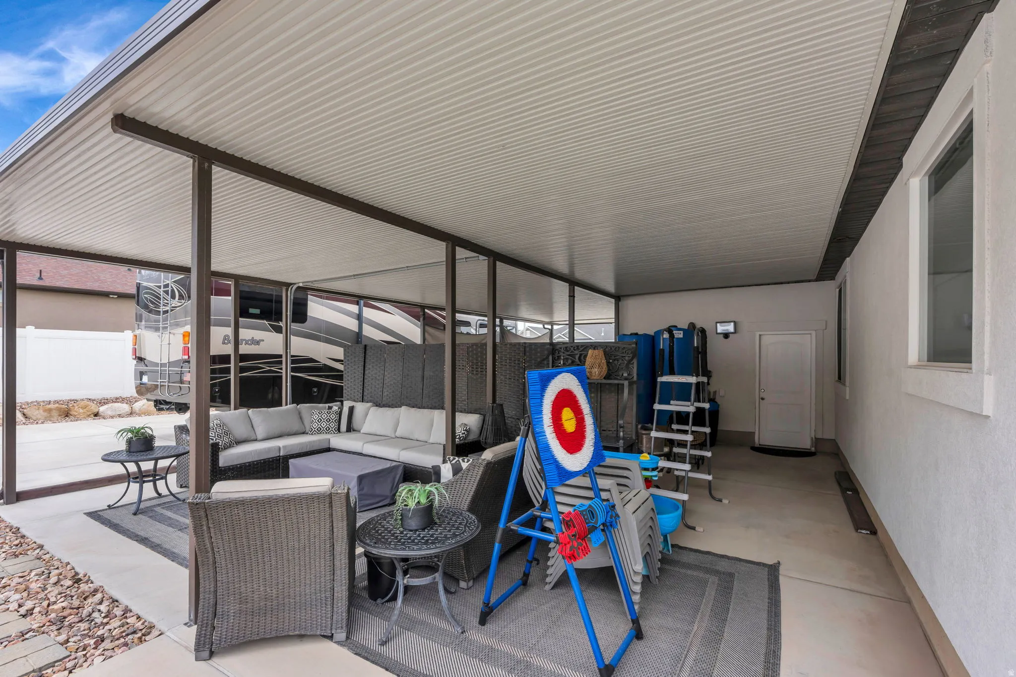 Expansive covered patio with a textured concrete slab and a durable metal roof